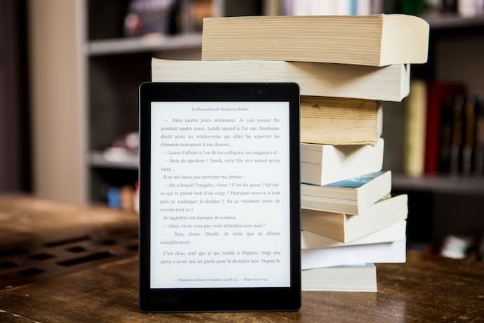 Pilha de livro e Kindle apoiado