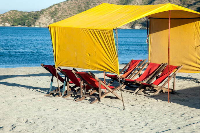 Tenda na areia da praia com cadeiras 